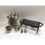 A cast iron trivet, a metal three piece coffee set