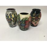 Three Moorcroft vases decorated with flowers and f