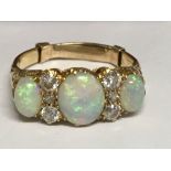 A 18 ct gold ring inset with three opals and six d