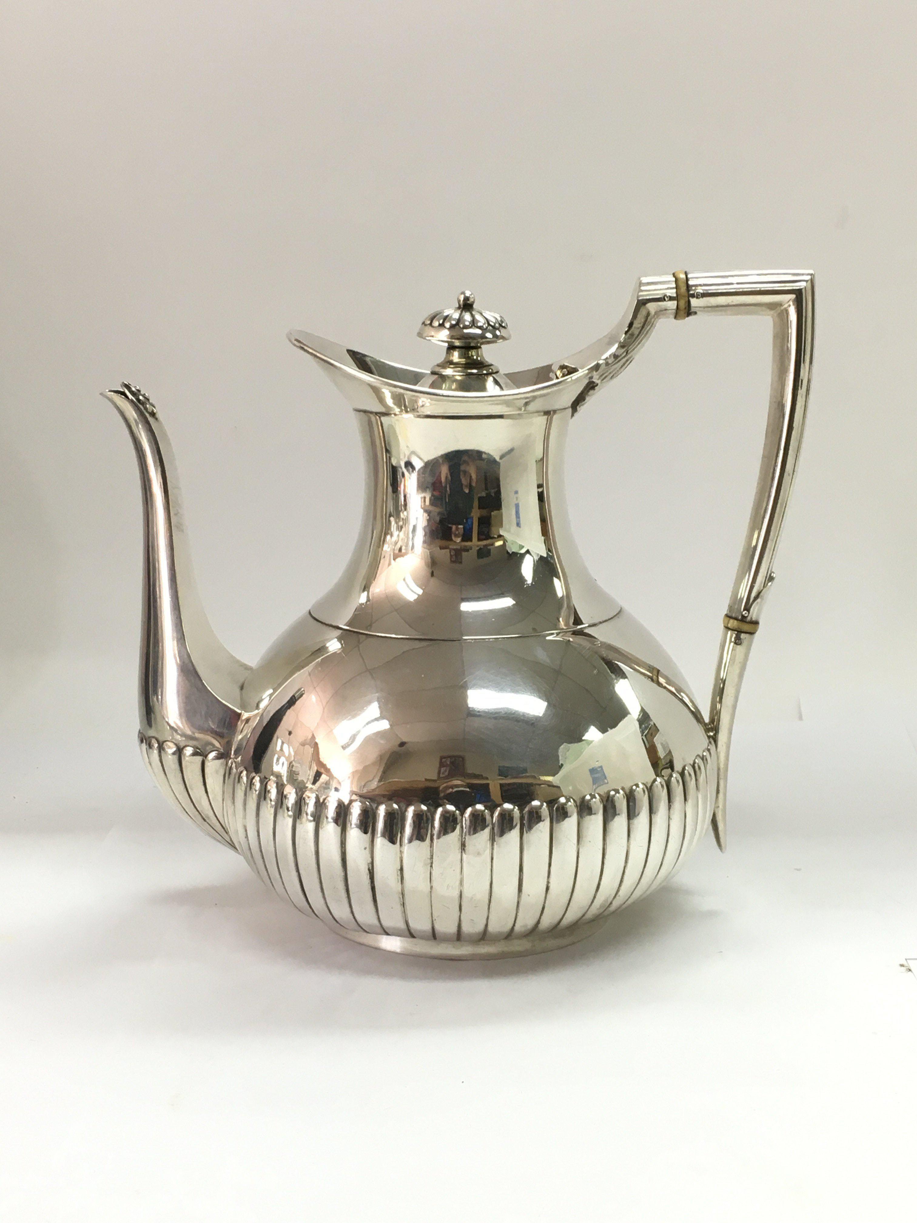 A silver teapot, London 1881 by W&J Barnard with half gadrooned decoration. Approx 726g.