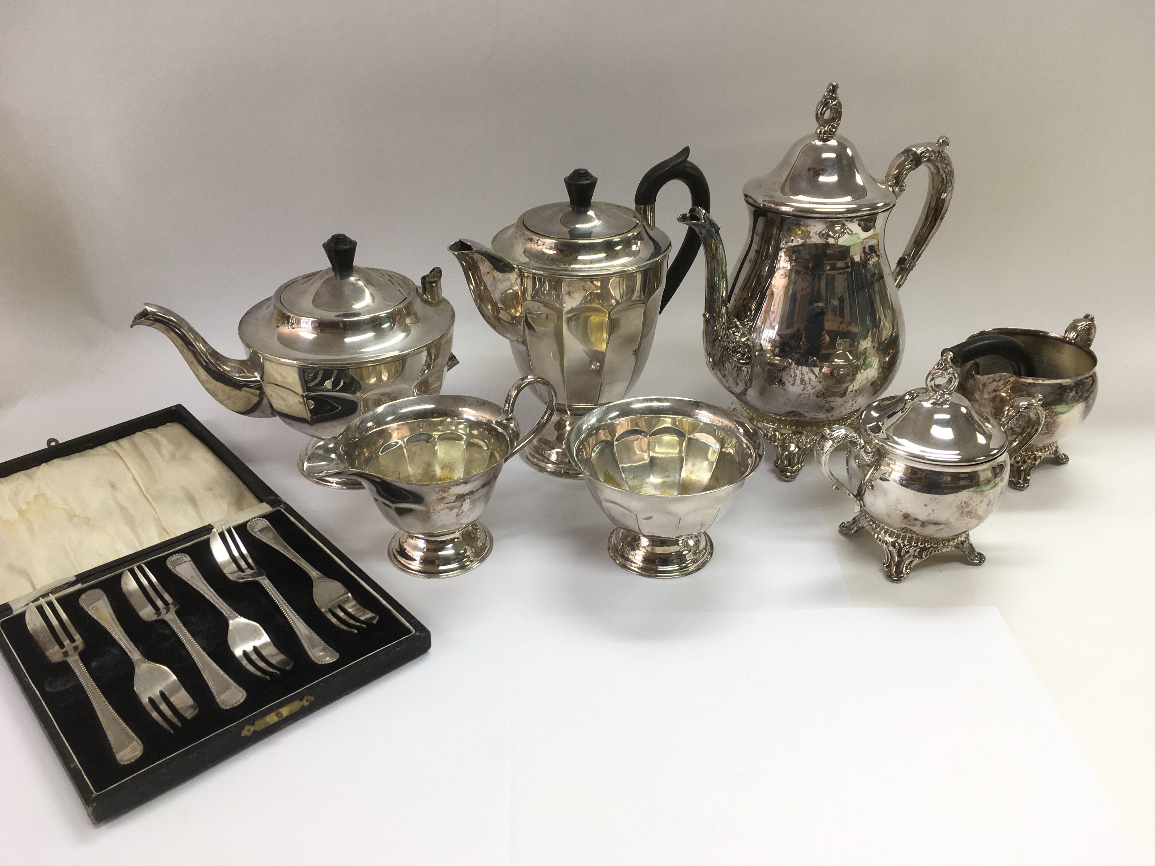 A collection of silver plated items including a tea and coffee service of scalloped form, cased