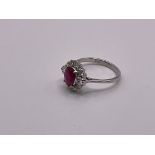 An 18ct white gold oval ruby and diamond cluster r