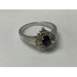 A 9ct white gold central oval cut sapphire surrounded by baguette and brilliant cut stones. R.