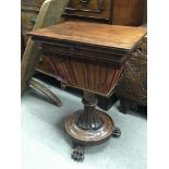 A Victorian Mahogany work box with a hinged top on a a turned column with stylised acanthus leaves