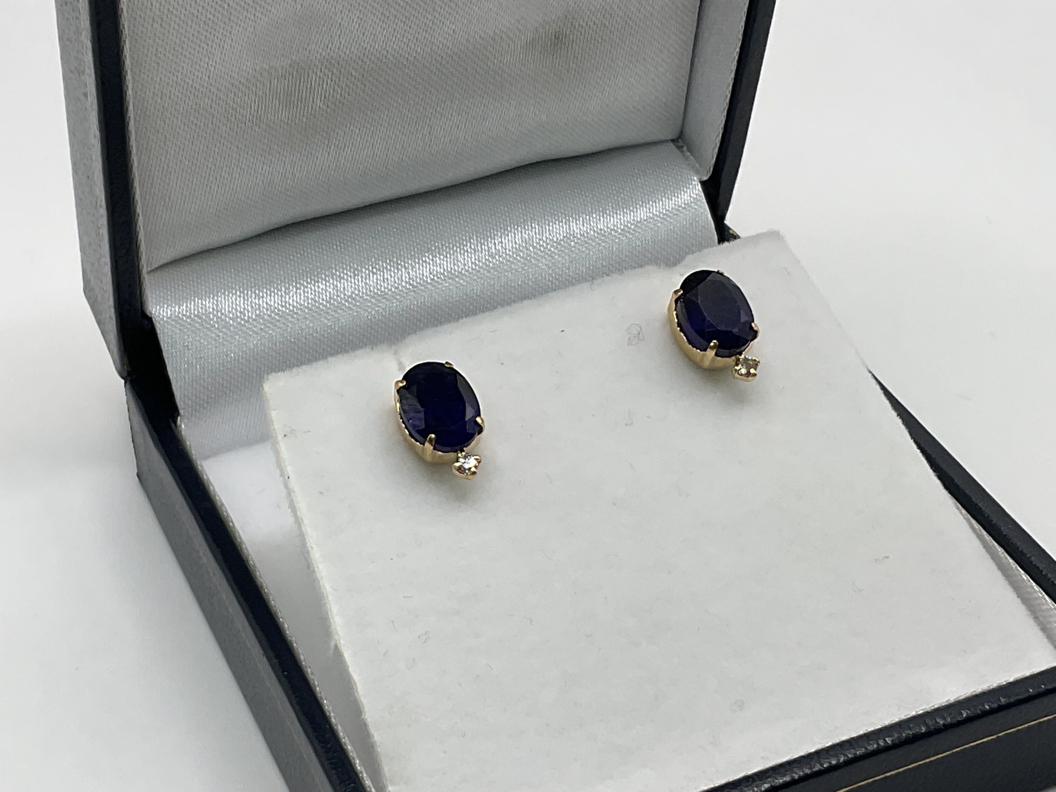 A pair of 18ct treated sapphire and diamond studs.