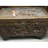 A Quality carved camphor wood trunk the top with fighting warriors. With brass mounts. Length 95cm