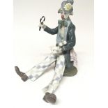 A Lladro figure of a clown holding a magnifying gl