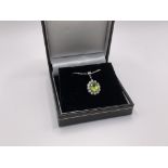 A 9ct white gold cluster pendant set with an oval