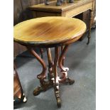 A walnut Victorian occasional table with a circular top and scroll supports. Top width 61cm