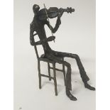 A modern bronze sculpture of a musician playing a