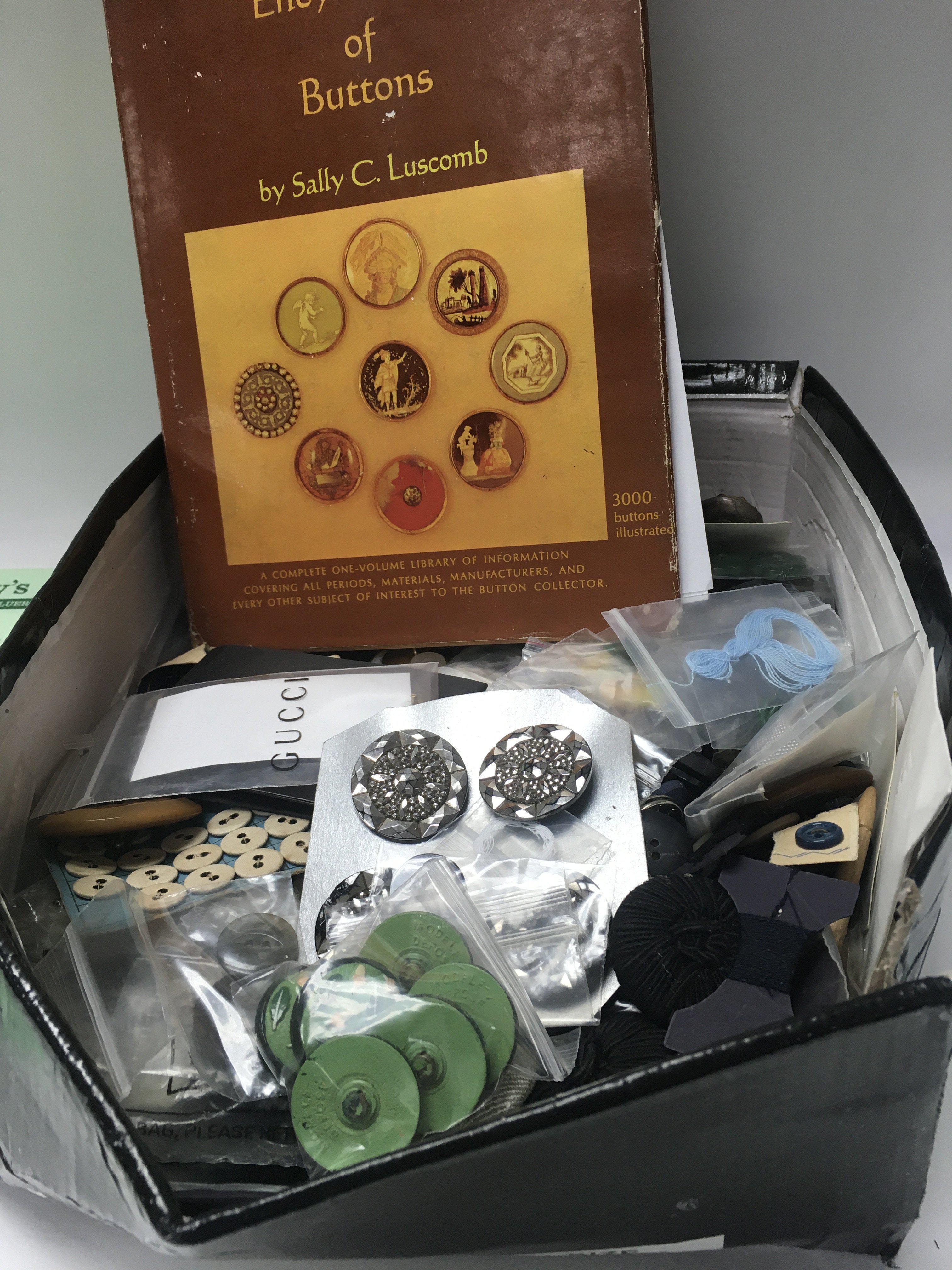 A box of various buttons together with the collector's Encyclopaedia of buttons.