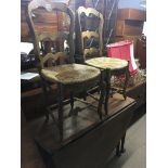 A pair of Continental beechwood occasional chairs and a George III oak drop leaf table. (3)