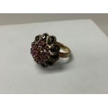 An 18ct gold ruby and black stone set dress ring. Size O.