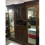 An Edwardian inlaid Mahogany wardrobe with bevelled edge doors the centre section with drawers and