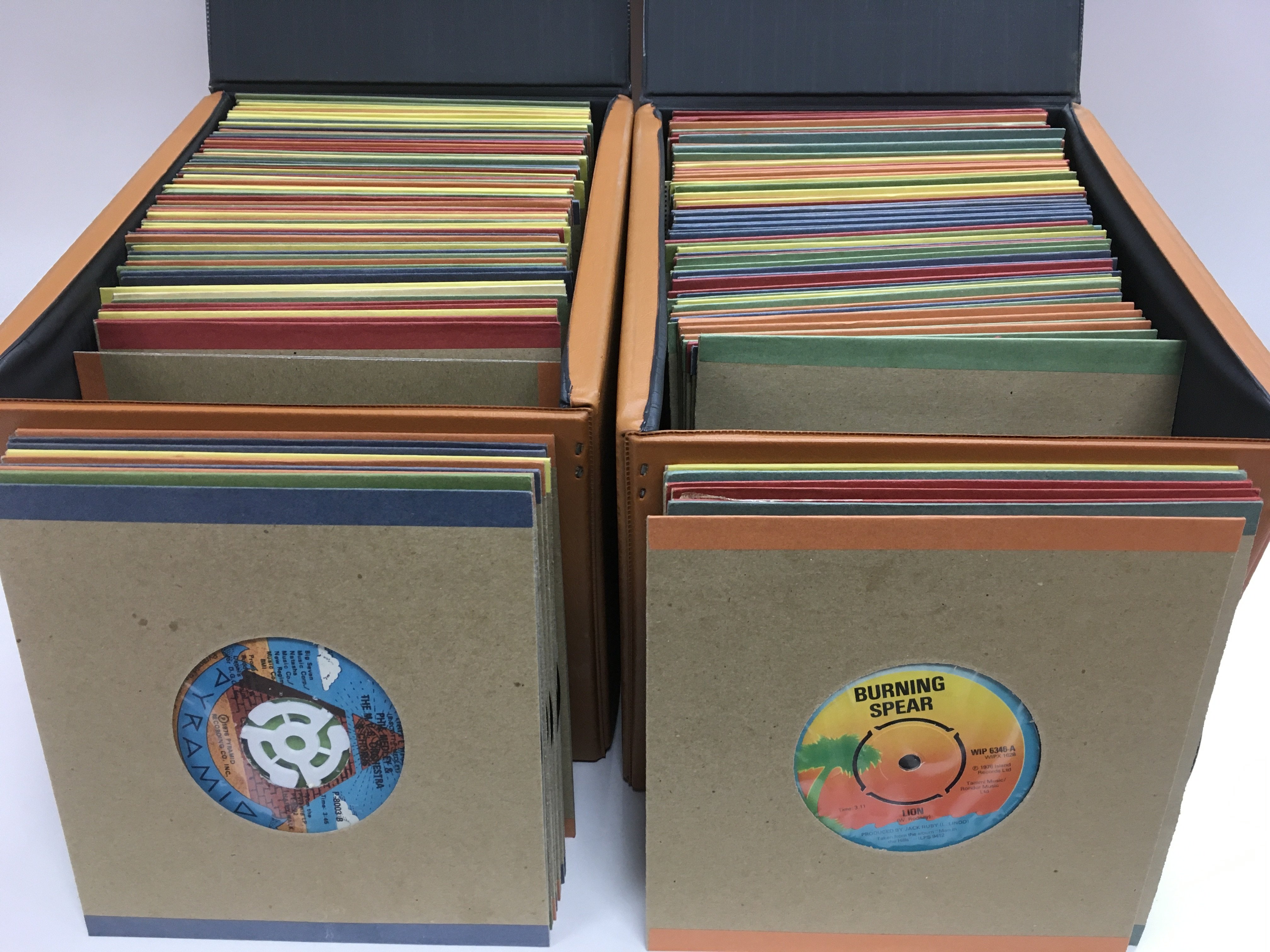 Four record cases of 7inch singles by various rock