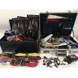 A metal case and a box of guitar accessories compr