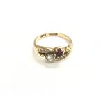 An 18ct gold ruby and diamond crossover ring. Size