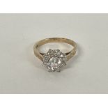 A multi stone cluster ring with engraved shoulders