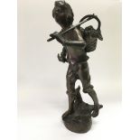 A bronze figure of a farmworker carrying a basket