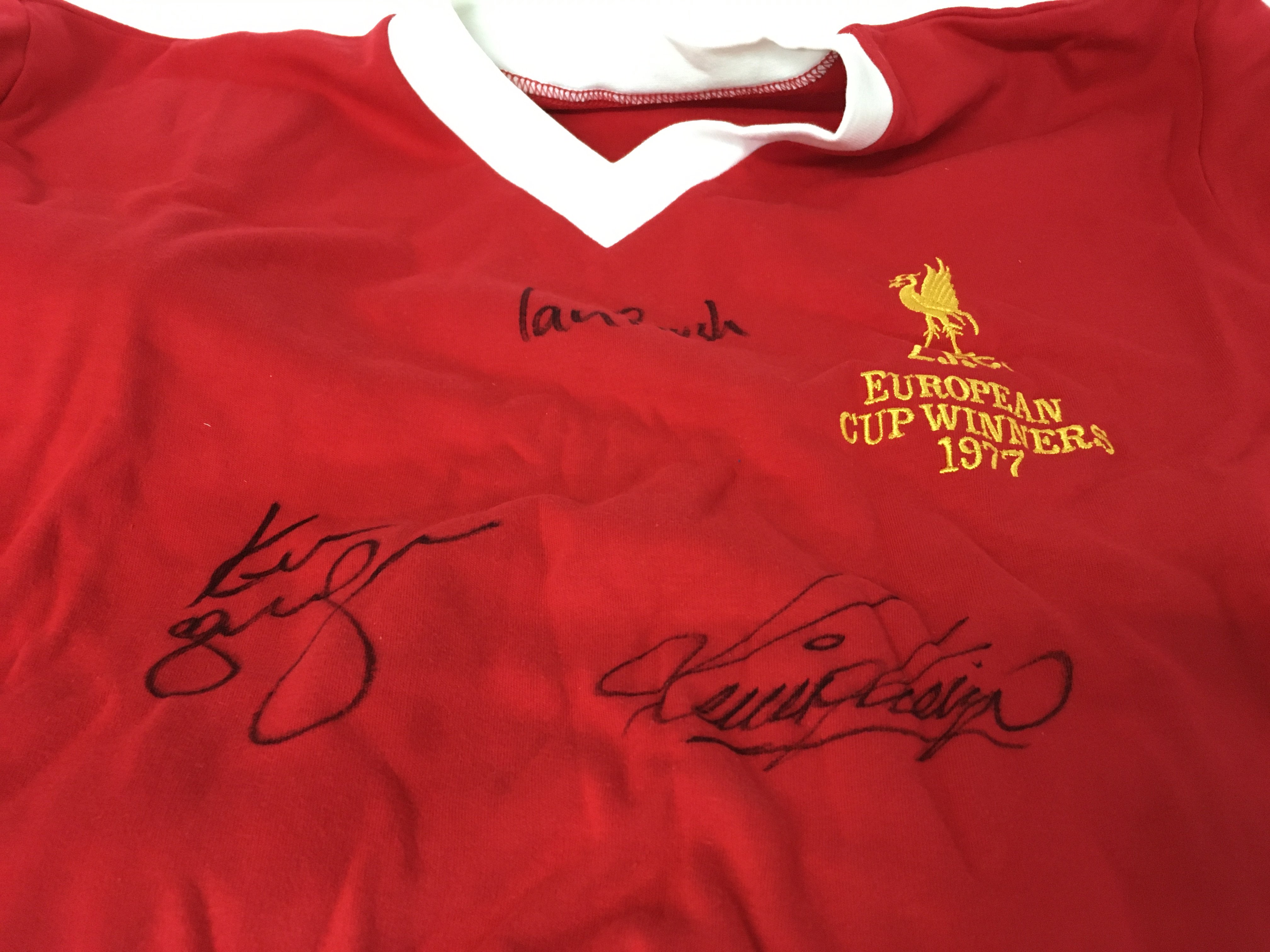 A Liverpool football shirt signed Kenny Dalglish ,