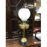 A brass oil lamp with a white glass shade, approx