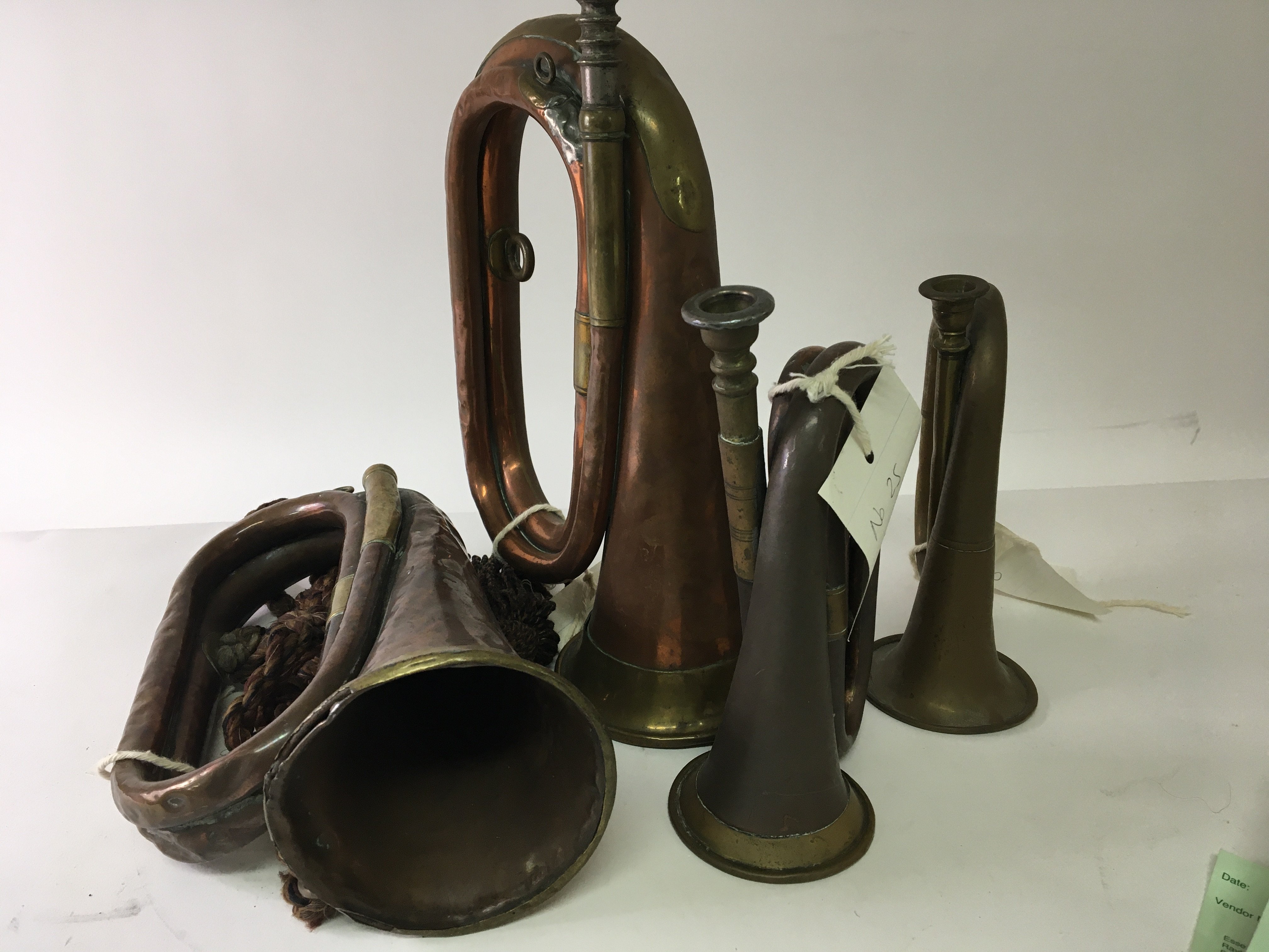 Four antique brass and copper bugles one with an i