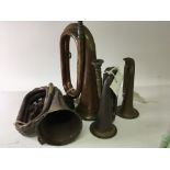 Four antique brass and copper bugles one with an i