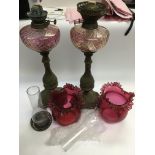 Two brass oil lamps with Cranberry glass shades an