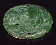 A 9ct gold brooch set with carved nephrite jade depicting a dragon, 12.4g, 4.3 x 3.2cm