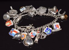 A silver charm bracelet with 28 silver/ 800 charms including plane, windmill, fish, stag, enamel