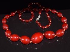 A single strand of forty eight oval graduated cherry amber beads, the largest bead approximately 2.7
