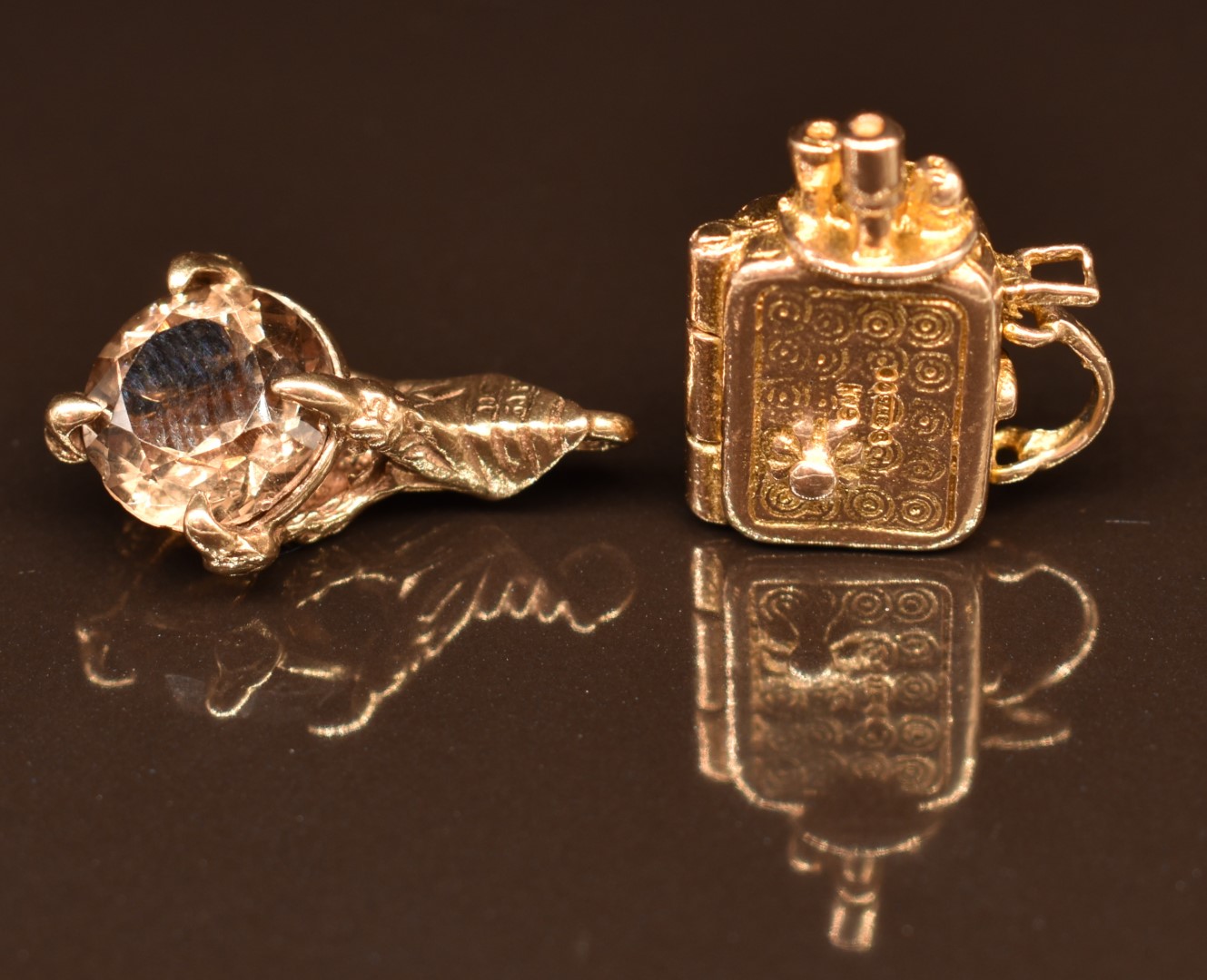 Two 9ct gold charms comprising a claw set with smoky quartz and a camera opening to reveal a lady,