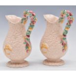 Clarice Cliff pair of pink Celtic Harvest pedestal jugs, H20cm