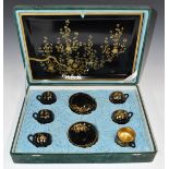 Black and gold lacquer coffee set comprising six cups and saucers with tray, in original fitted