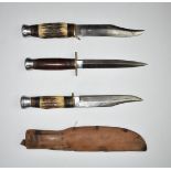 Two hunting knives both with 15cm 'Bowie' style blades, one with sheath, together with a stiletto