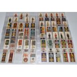 Approximately one hundred John Player's cigarette cards featuring military uniforms and cap badges