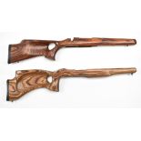 Two laminated show wood target rifle stocks, both with thumb hole grips, raised cheek pieces and