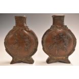 A pair of Japanese Meiji period bronze moon flasks decorated to both sides with performing circus