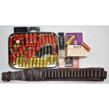 A collection of shotgun and rifle cartridges together with a leather cartridge belt. PLEASE NOTE