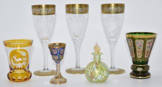 Six various drinking glasses comprising a set of three Moser style wine glasses with gilt decoration
