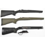 Three composite bolt-action rifle stocks comprising two Howa and one SSG, all with sling mounts.