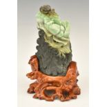 Chinese carved jade boulder with crab and flower decoration, on wooden stand, 22cm tall.