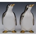 A pair of ceramic penguins with cream and chrome finish, 24.5cm tall.