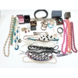 A collection of costume jewellery including bangles, two silver mounted items, beads, abalone