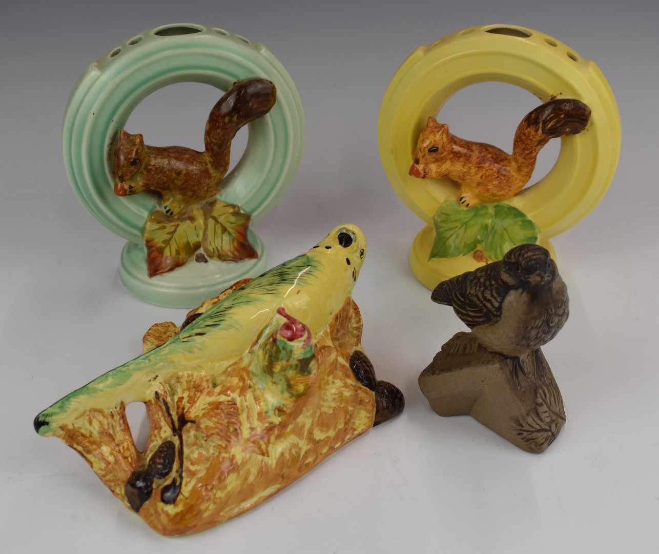 Two Burleigh Ware squirrel flower frogs, budgie wall pocket and a Poole pottery bird, tallest 20cm