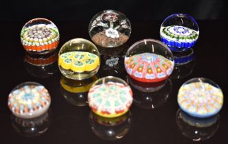 Eight glass paperweights mostly with millefiori decoration, some with latticino canes, including