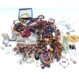 A collection of costume jewellery including wooden beads, brooches, earrings, etc