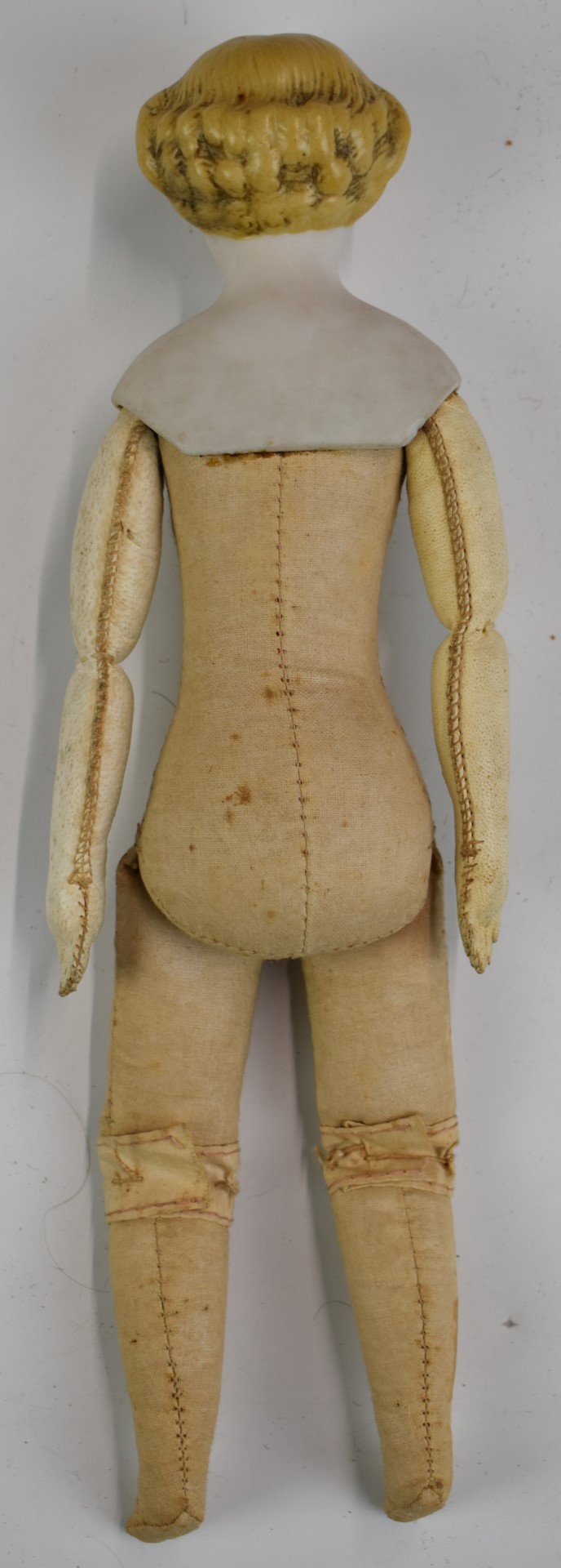 A 19thC bisque headed doll with painted features, cotton body and kid leather arms, 25cm tall. - Bild 4 aus 4