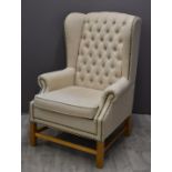 Contemporary wing backed upholstered armchair with button back and studded decoration, width 82cm
