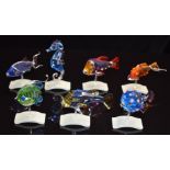 Seven Swarovski Crystal Paradise coloured glass tropical fish all raised on wave bases, the seahorse
